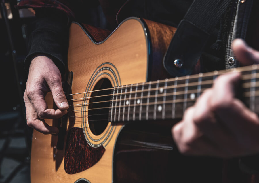 Classical acoustic guitar in the hands of a musician.
