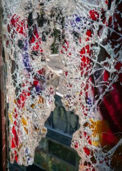 Broken glass windows in an old abandoned building or factory, completely destroyed and vandalized, painted with colourful graffiti street art
