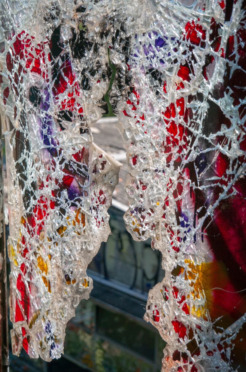 Broken glass windows in an old abandoned building or factory, completely destroyed and vandalized, painted with colourful graffiti street art