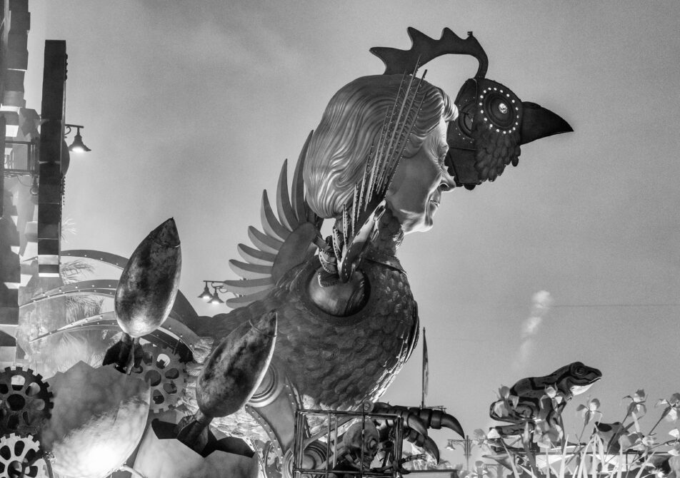 Evening Carnival procession of allegorical floats at Viareggio with masks music and nighttime lights.