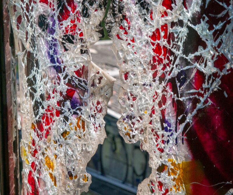 Broken glass windows in an old abandoned building or factory, completely destroyed and vandalized, painted with colourful graffiti street art